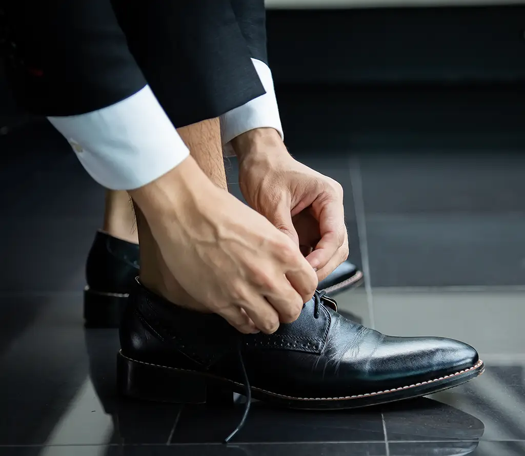 Mann im Anzug zieht Schuh an